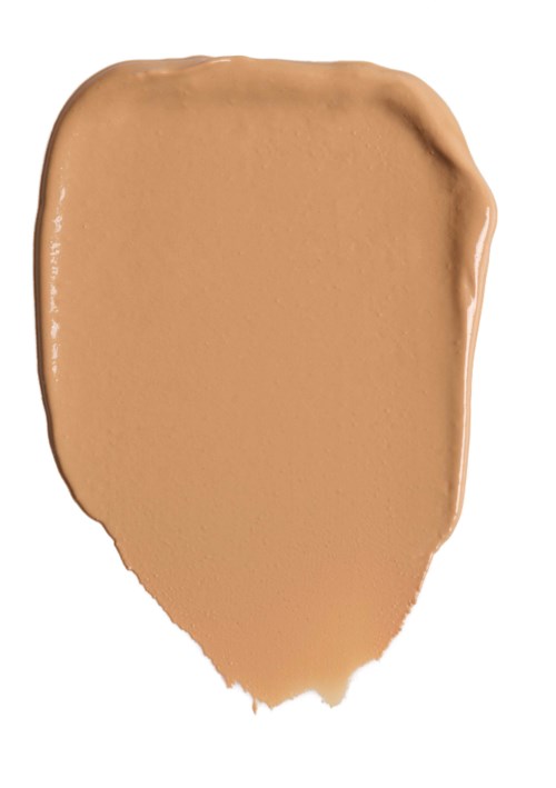 En beige smøre av sminke eller foundation på en hvit bakgrunn.