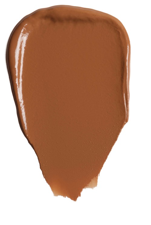 En brun væske spredd på en hvit overflate, formet som et blad.