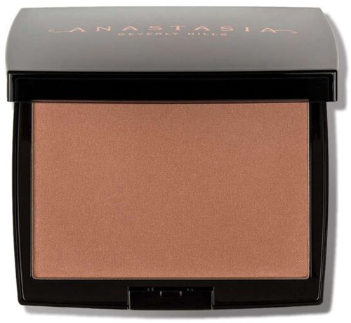 En makeup-compact med en persikofärgad puder inuti och ett frostat skal med märket på locket.