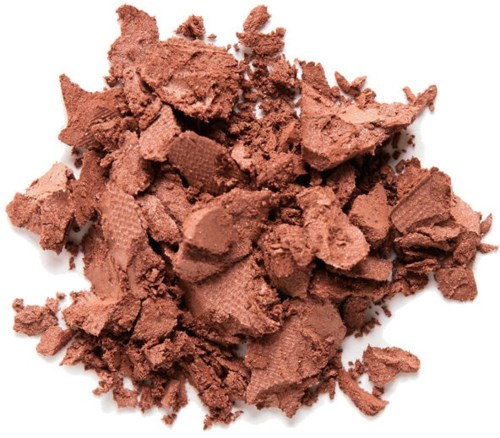 Krossad brunt makeup puder på en vit bakgrund.