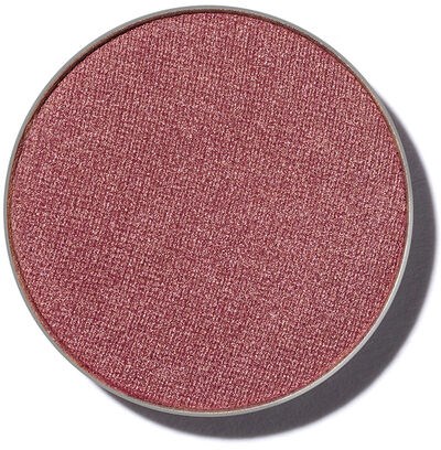 En rund makeup-rouge eller ögonskugga i rosa färg med metallisk skugga.