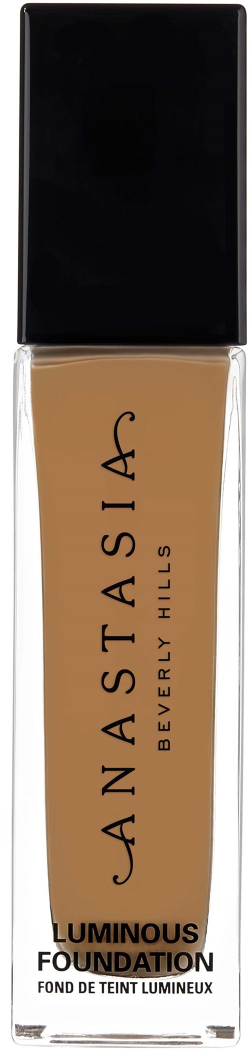 En flaska av foundationsmink med svart lock, beige vätska inuti, och text i svart på framsidan.