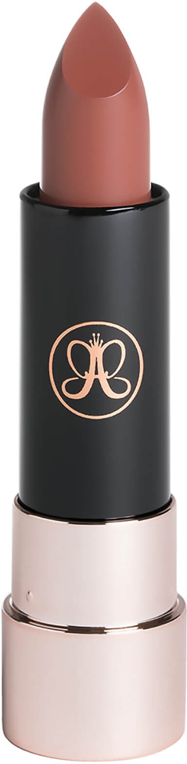A lipstick with a black and gold case and soft pink color. The case has a logo on it.