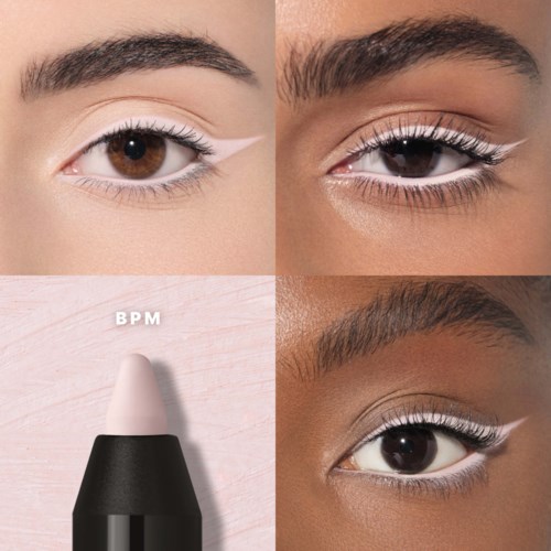 Nærbilde av øyne med hvit eyeliner og mascara, med en svart og hvit øyenprimer eller concealercirkel i nederkant til venstre.
