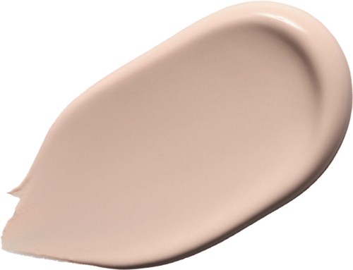 Kremsfoundation i en tårform, slät och beige i färgen.