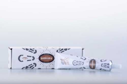 Een tandpastatube en doos met een ontwerplabel, geplaatst op een witte achtergrond.