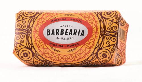 Saippua, jossa on koristeellisia mustia ja oransseja kuvioita ja punainen ja valkoinen etiketti. Siinä lukee 'Antiga Barberia'.
