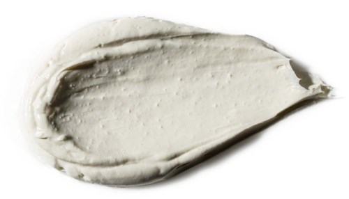A dollop of white creamy substance on a black background, smooth with soft peaks.