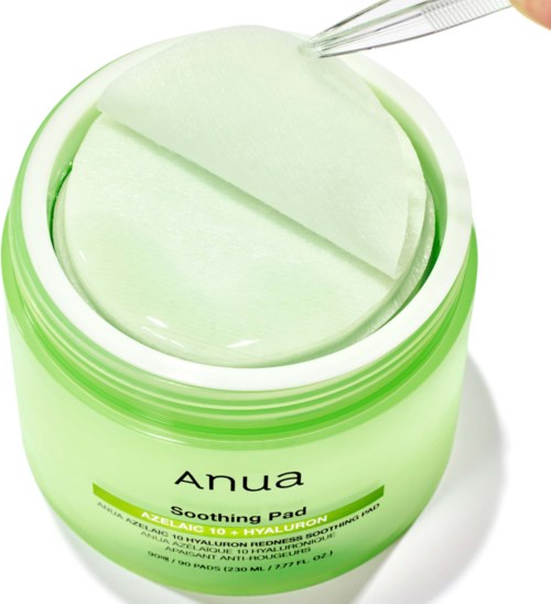 Öppen grön burk med Anua lugnande pads med en bomullspad inuti och en dropper ovanför.