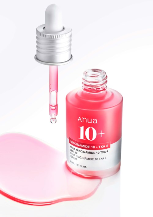 En rosa flaska märkt 'Anua 10+', med en dropper och lite rosa vätska spilld.