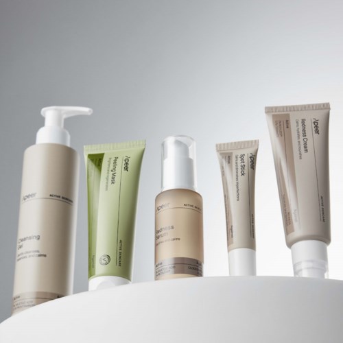 Various skincare products in bottles and tubes, arranged on a white surface against a light background.