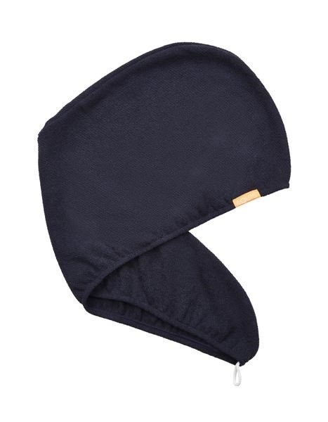 En mörkfärgad vintermössa med öronlappar och en liten beige tag på sidan.