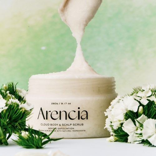 Eine weiße Dose mit der Aufschrift Arencia, umgeben von weißen Blumen und grünen Pflanzen. Weißes Pulver wird in die Dose gegossen.