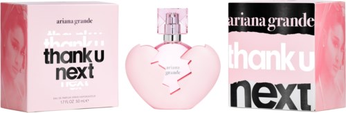A perfume bottle shaped like a broken heart, with pink color and white accents, between two boxes with brand names.