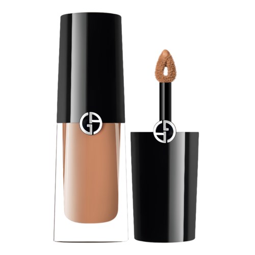 En beige flydende foundation i en sort flaske med et spejlende logo og en applikator med svampespids.