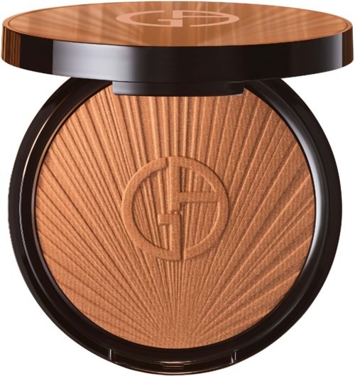 A compact, circular makeup powder with a sunburst pattern and a logo in the center, enclosed in a black case.