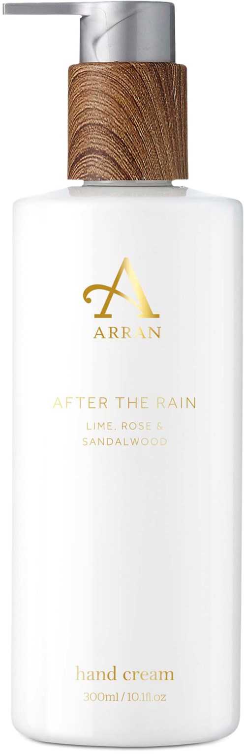 Hvit håndkremflaske med trepump og gulltekst, merket 'Arran After the Rain.'