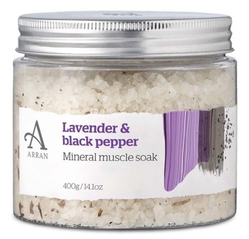 En burk med lavendel och svartpeppar mineral muskelbad med silverlock och lila design.