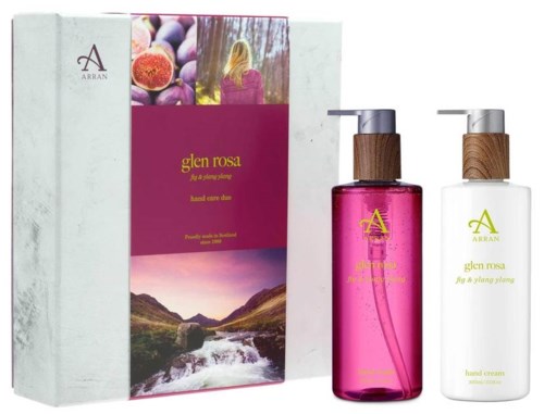 Ett hudvårdspaket med två flaskor, en rosa och en vit, med träpumpor, i en förpackning med naturbilder.