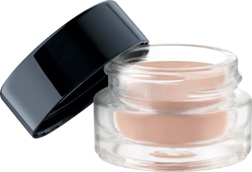 Glass jar of light beige cream with black lid resting on top.