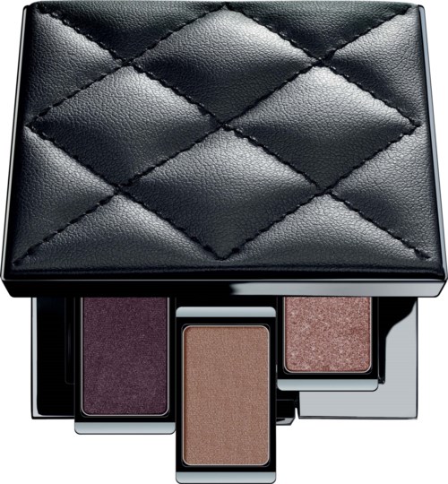 A black quilted case holding three eyeshadow pans in purple, brown, and pink shades.