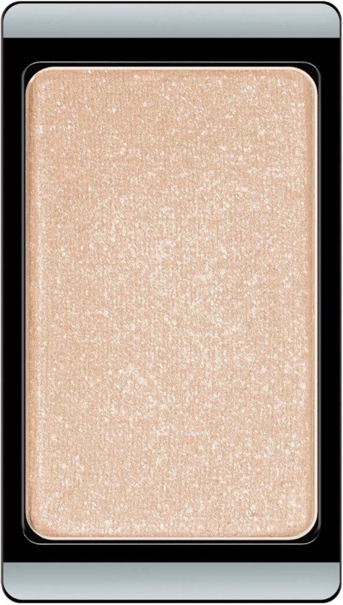 A shimmering beige highlighter with a textured surface in a black makeup compact.