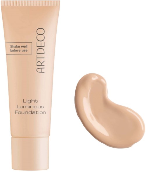 A tube of foundation with a swatch of beige color beside it. The tube has instructions to shake before use.