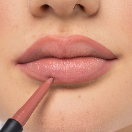 A person applies lip gloss or lip color to lips near the center of the bottom lip.
