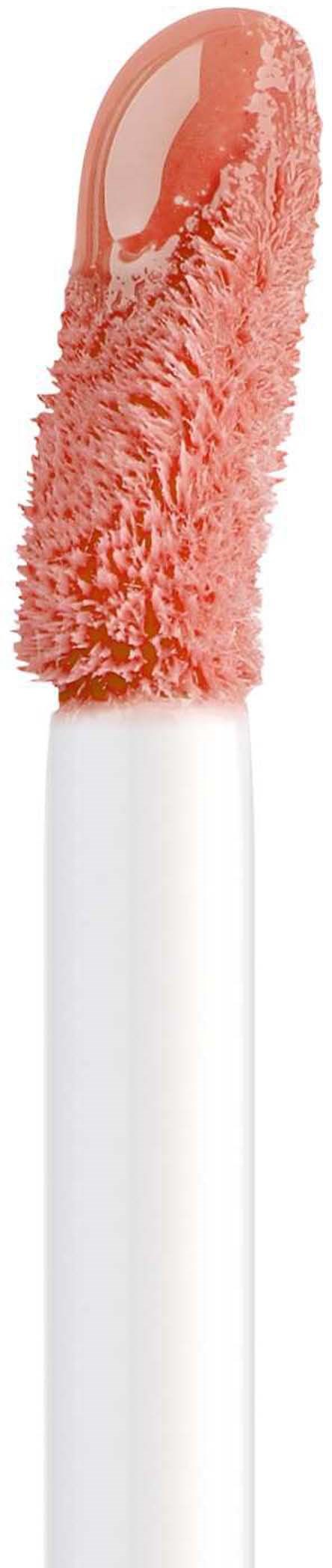En makeup-pen med en fluffy, orange-rosa svamp og et hvidt håndtag.