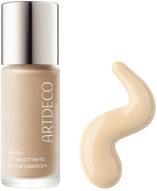 En flaske ARTDECO Rich Treatment Foundation med en prøve av den beige fargen ved siden av.