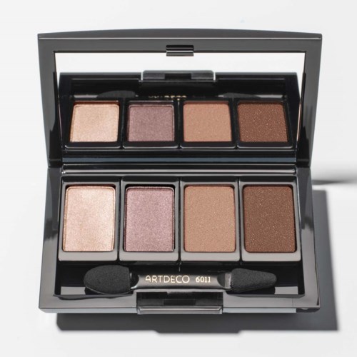 En sort makeuppalette med fire øjenskygge nuancer, åben for at vise shimmer og matte farver, med en lille svampeapplikator.