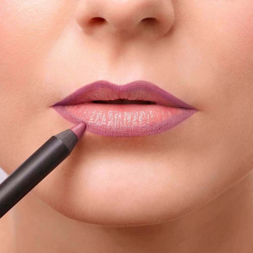 A person is applying pink lipstick to their lips with a pencil. Close-up of mouth and chin area.