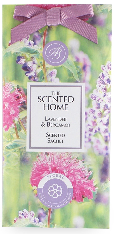 Lavendel og bergamot duftende pose med lilla bånd og blomsterbakgrunn.