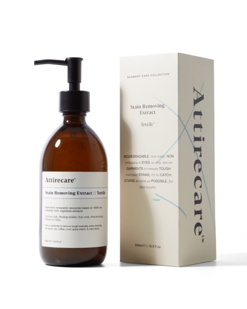Ein braune Pumpflasche mit Etikett Attirecare und eine Schachtel daneben, beide für Fleckenentfernung bei Textilien.