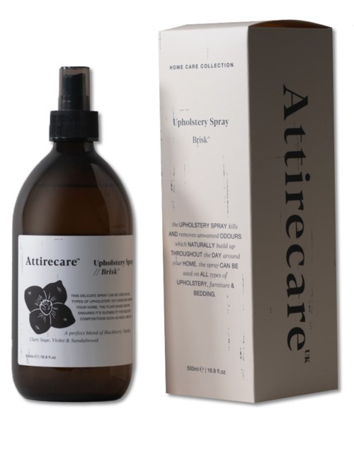 A brown spray bottle with a white label and black cap, next to a white box with black text, labeled 'Attirecare' and 'Upholstery Spray'.
