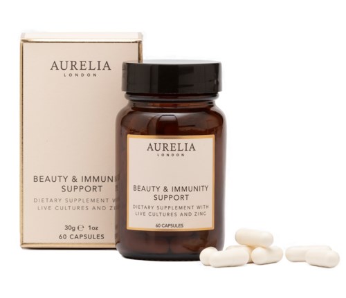 Aurilia London tilskudd, flaske merket for immunforsvar, noen hvite kapsler utendørs på en hvit bakgrunn.