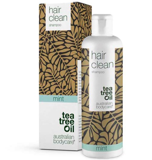 En flaske og eske med hårsjampo med te-treolje og mynte, fra Australian Bodycare, med et bladmønster.