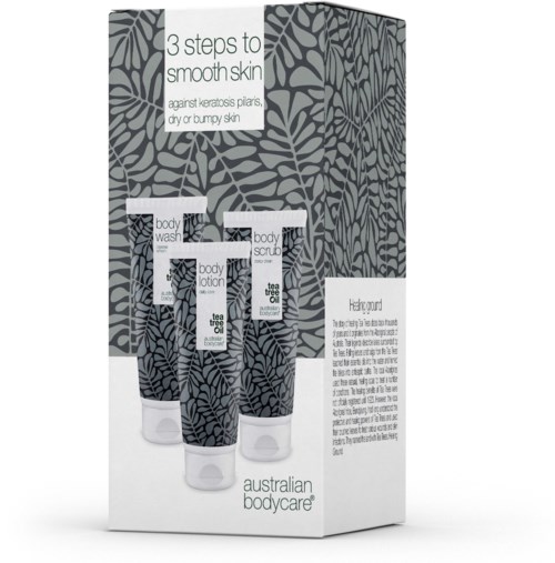 A skincare set with three products: body wash, lotion, and scrub, on packaging with leaf patterns and instructions for smooth skin.
