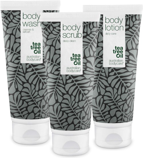 Three tubes of body care products: body wash, body scrub, and body lotion with tea tree oil design.