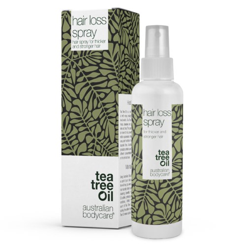 En hvit sprayflaske med grønt bladmønster, merket 'hair loss spray' med tea tree olje for tykkere hår.