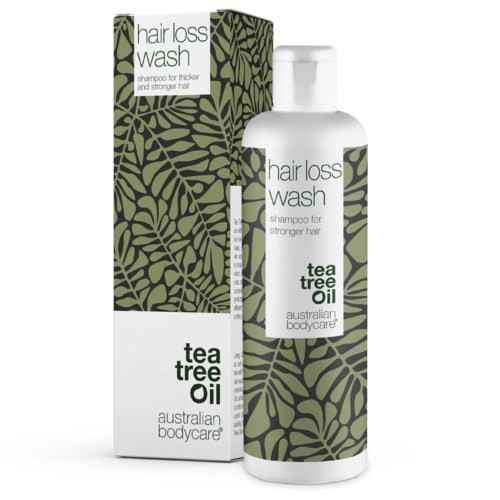 En hvid flaske med grøn og sort bladdesign, mærket tea tree olie shampoo mod hårtab. Følger med en matchende æske.