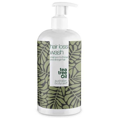 En tydlig flaska med pump innehåller te tree oil-schampo för tjockt, starkt hår, märkt med gröna bladmotiv.