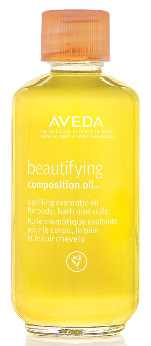Keltainen pullo, jossa pinkki korkki, labeled 'Aveda beautifying composition oil' vartalo ja päänahan.