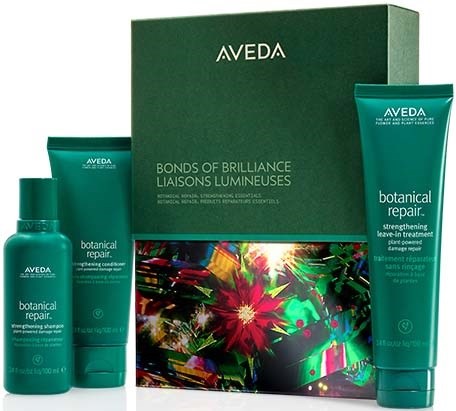 Drei grüne Haarpflegeprodukte, eine Box mit Blumen- und buntem Design, und die Marke Aveda sind sichtbar.