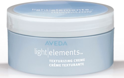 Ympyrän muotoinen rasia, jossa on valkoinen kansi ja vaaleansininen runko, sisältää Aveda light elements tekstuurointivoiteen.