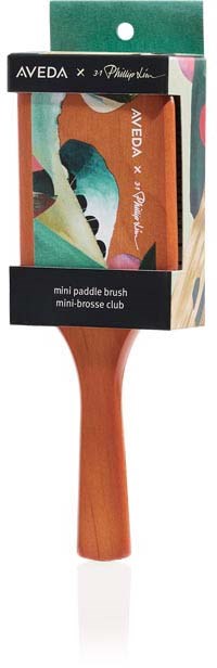 A small paddle brush in colorful packaging, with a wooden handle and a printed label with brand and product name.