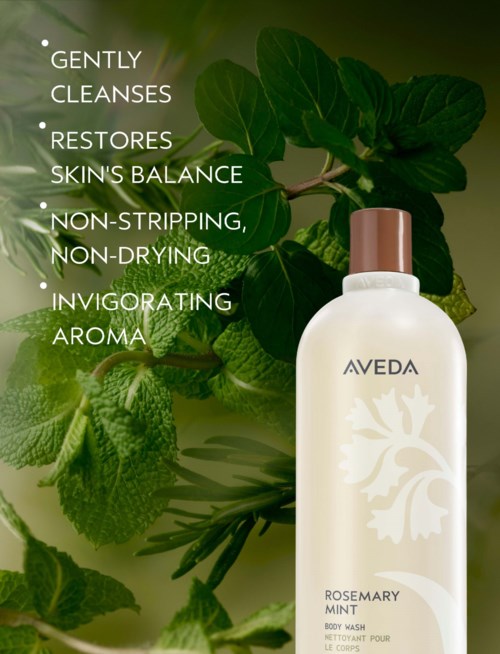 En hvid flaske med Aveda Rosemary Mint kropsvask blandt grønne mynteblade, med produktfordele listet til venstre.