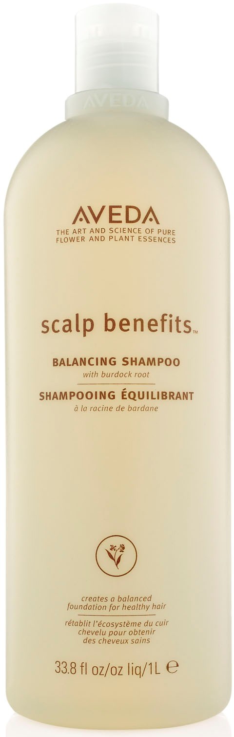 En hvit flaske med Aveda scalp benefits balanserende sjampo med tekst i brunt og oransje, med hvit kork.