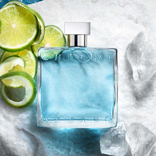 Niebieska butelka perfum GHROME AZZARO, otoczona plasterkami limonki i kostkami lodu.