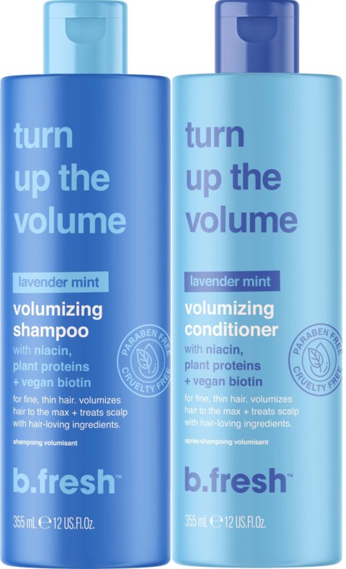 Two blue bottles, one for shampoo and one for conditioner, with white and purple text about volume and lavender mint scent.